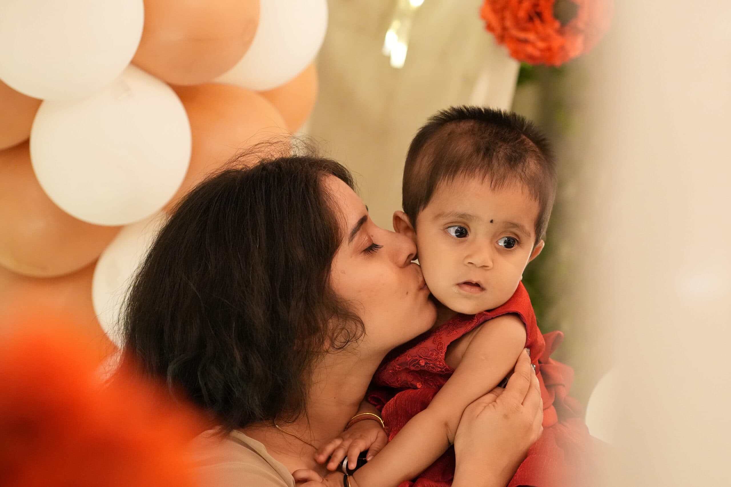 A mother kissing her baby daughter