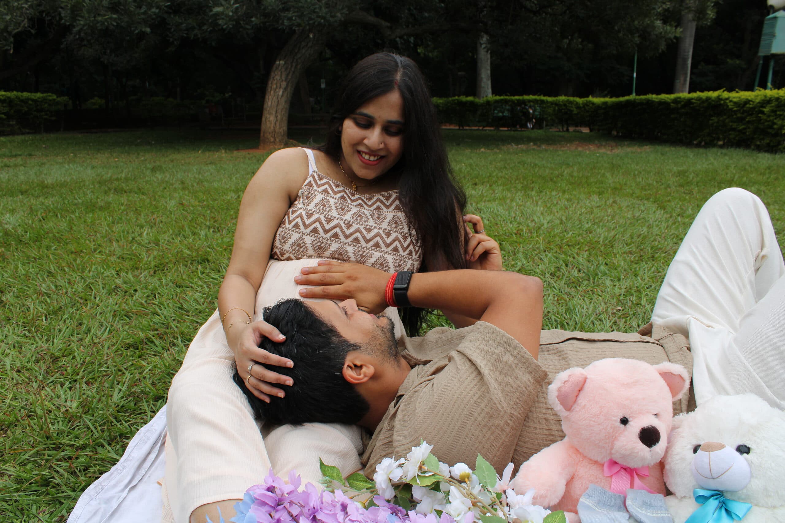Expecting parents on a picnic blanket in the park